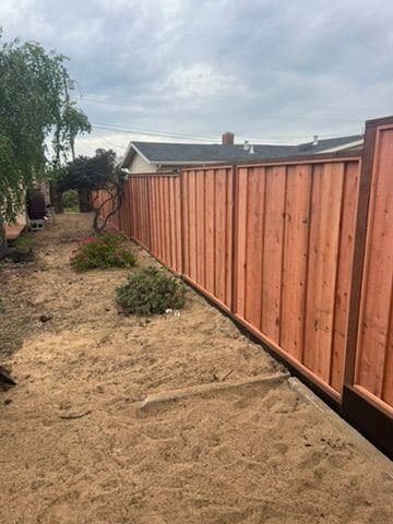 Long cedar privacy fence running along a backyard
