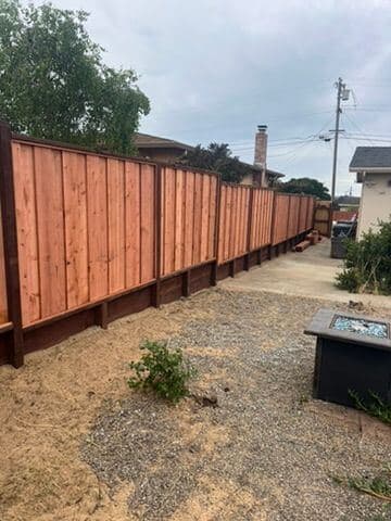 Wide view of a finished cedar privacy fence line and yard