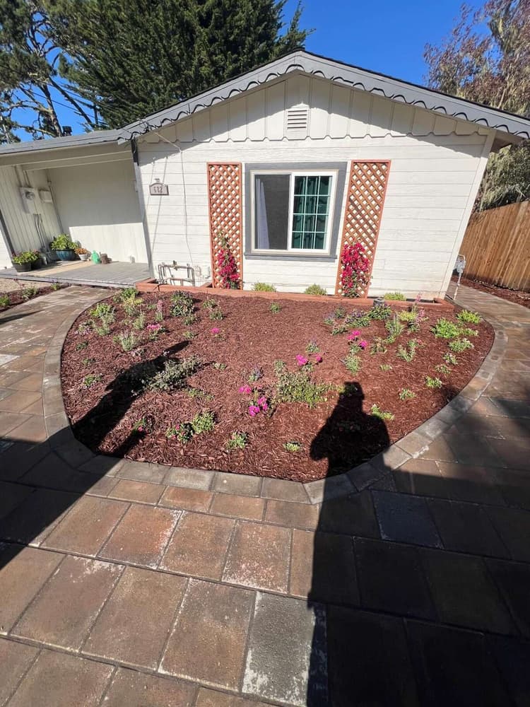 Circular paver patio and mulch bed with lattice and trellises