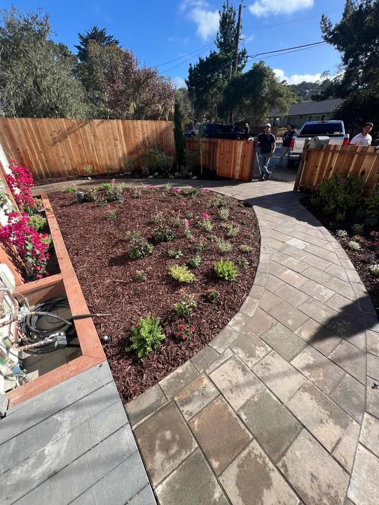 Paver patio and mulch bed with a new wood fence behind